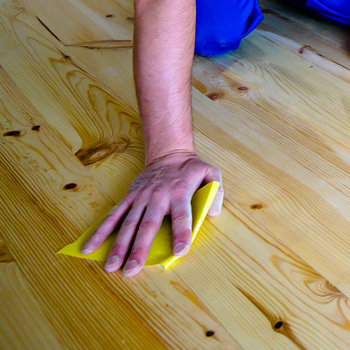 close up of a contractors hands working on hardwood floor refinishing lawndale ca